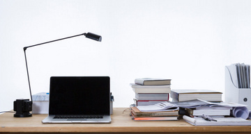 Schreibtisch mit Laptop, Lampe und Utensilien für ein Online-Training