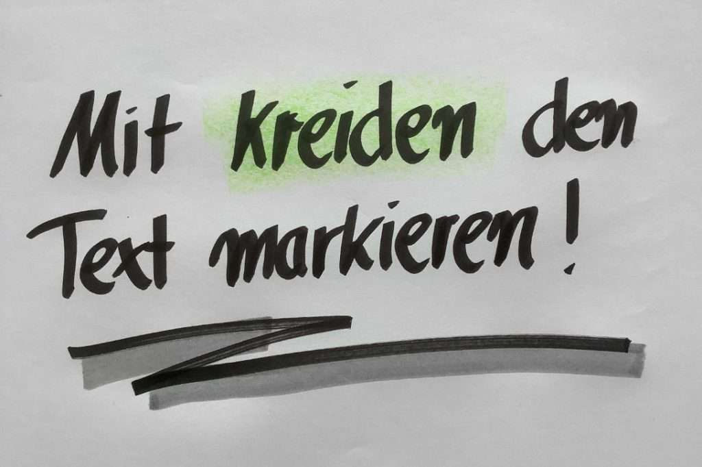 Das Bild zeigt den Text "Mit Kreiden Text markieren!". Dabei ist das Wort "Kreiden" mit grüner Kreide farblich hervorgehoben. 
