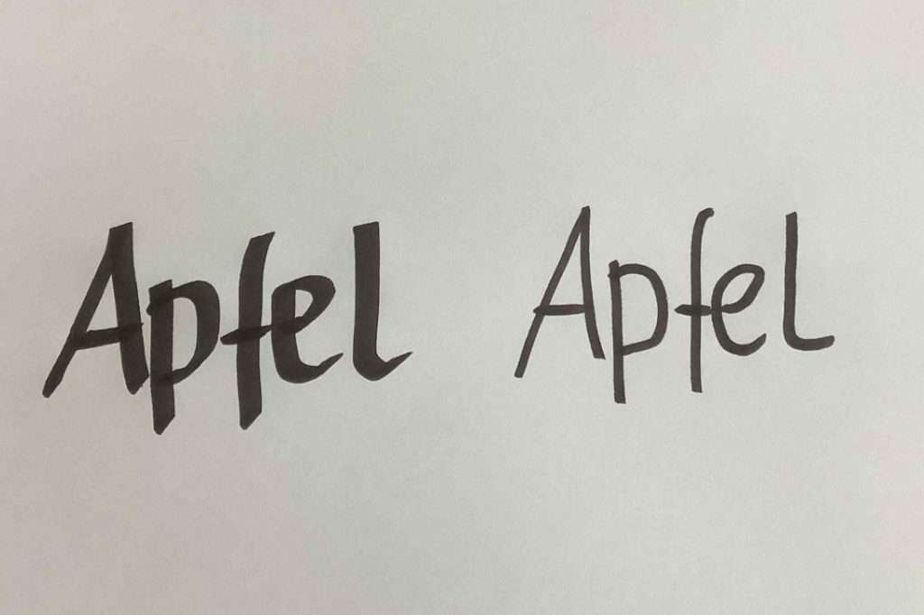 Das Bild zeigt zweimal das Wort „Apfel“, nebeneinander auf weißem Papier geschrieben. Links ist das Wort mit dicken und gut sichtbaren Buchstaben geschrieben. Die Striche sind unterschiedlich breit. Aus der Entfernung ist das Wort gut zu erkennen. Rechts steht das gleiche Wort nochmal, aber mit dünneren Linien. Es wirkt schwächer und ist aus der Entfernung schwerer zu lesen. Das Bild zeigt: Wenn Du Flipcharts gestalten willst, ist es wichtig, den Stift richtig zu halten. So entstehen kräftige, lesbare Buchstaben – wie auf der linken Seite.