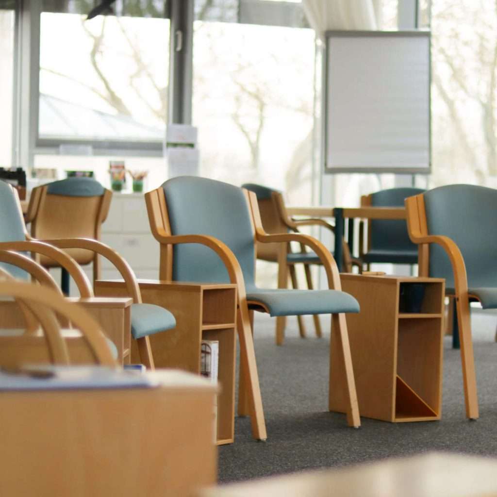 Das Bild zeigt ein paar Stühle in einem hellen Raum. Im Hintergrund ist ein Flipchart zu sehen und eine Glasfassade. Es zeigt den Seminarraum von abb-seminare, in dem die NLP Ausbildung in Leipzig stattfindet.