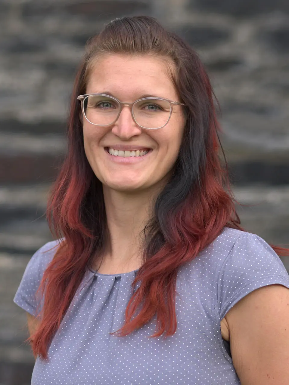 Auf dem Bild ist eine das Portrait einer Frau zu sehen. Sie trägt eine Brille und hat lange Haare. Das Bild zeigt Alexandra Häßler. Sie ist bei abb-seminare für die Coachingausbildung verantwortlich und die Ansprechpartnerin.